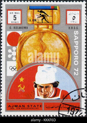 Il francobollo del 1972 di Ajman raffigura Galina Kulakova, una famosa atleta sovietica. Il francobollo celebra i suoi successi nello sci di fondo, segnando un momento significativo nella storia dello sport. Foto Stock