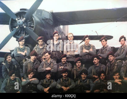 Questa immagine mostra i paracadutisti che saltano da un aereo Antonov An-2, un biplano dell'era sovietica utilizzato per una varietà di scopi, tra cui lanci aeree. I paracadutisti stanno eseguendo un salto con paracadute, uno sport popolare e un allenamento. Foto Stock