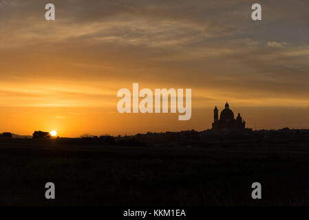 Tramonto dietro la Basilica di San Giorgio creando una silhouette , Victoria Gozo Malta Europa Foto Stock