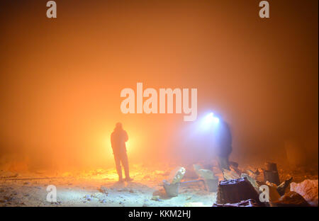 Miniere di zolfo operanti in notturna a kawah ijen per evitare il calore solare durante il giorno. orange la luce generata dalla fiamma di torcia sul gas diossido di zolfo. Foto Stock