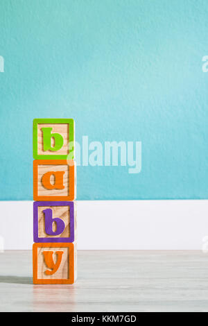 Cubi di legno con lettere con 'baby' parola su bianco tavolo in legno. copyspace. Foto Stock