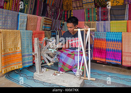 Tessitore indonesiano tessendo tessuti tradizionali di songket su telaio in legno primitivo nel villaggio di Sasak Sade sull'isola di Lombok, Indonesia Foto Stock