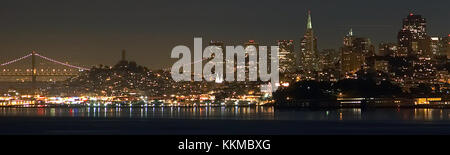 Lo skyline di San Francisco di notte offre una vista mozzafiato dei monumenti più rappresentativi della città, tra cui il Golden Gate Bridge e gli edifici del centro. L'architettura della città e le luci sul lungomare creano una suggestiva scena urbana dopo il tramonto. Foto Stock