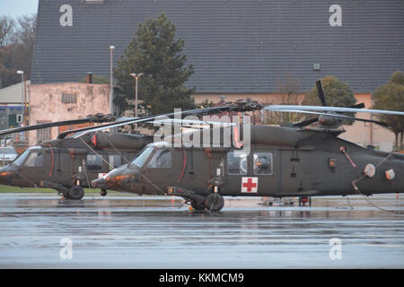 In una fredda e ventosa, pomeriggio piovoso, Black Hawk elicotteri da 2-227esimo reggimento di aviazione, 1° aria brigata di cavalleria di Fort Hood in Texas sedersi sulla linea di volo a Katterbach Army Airfield in Ansbach, Baviera, Germania, nov. 21, 2017. L'2-227esimo reggimento di aviazione, 1° aria brigata di cavalleria è su un periodo di nove mesi di rotazione in sostegno della Atlantic risolvere. Atlantic risolvere è una dimostrazione di continuato impegno degli Stati Uniti per la sicurezza collettiva attraverso una serie di azioni destinate a rassicurare gli alleati della NATO e partner di America la dedizione per una pace durevole e la stabilità nella regione. (U.S. Phot dell esercito Foto Stock