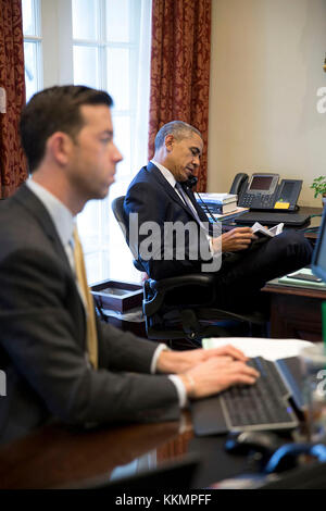 Il presidente Barack Obama parla al telefono con la casa leader dei democratici Nancy Pelosi, d-calif., seduti nella parte esterna ufficio ovale, Marzo 26, 2015. brian mosteller, direttore dell ufficio ovale operazioni, lavora alla sua scrivania. (Official white house photo by pete souza) Questo ufficiale della casa bianca fotografia viene reso disponibile solo per la pubblicazione da parte di organizzazioni di notizie e/o per uso personale la stampa dal soggetto(s) della fotografia. la fotografia non possono essere manipolati in alcun modo e non può essere utilizzata in ambienti commerciali o materiali politici, pubblicità, e-mail, prodotti promozioni che in Foto Stock