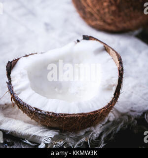 Rotto il cocco sul vecchio di legno. Sfondo immagine quadrata con il fuoco selettivo Foto Stock