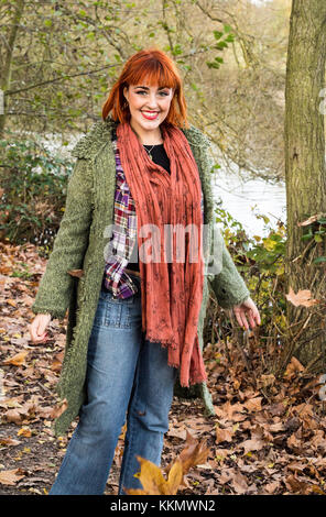 Ragazza camminare sulla strada forestale in autunno con foglie Foto Stock