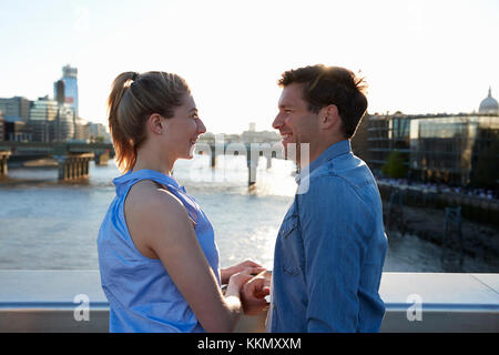 Coppia romantica in piedi sul ponte sul Fiume Tamigi a Londra Foto Stock