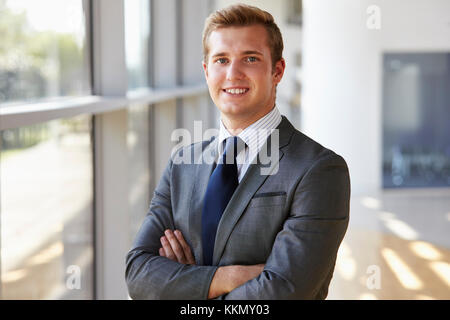 Ritratto di un giovane sorridente uomo professionale, con le braccia incrociate Foto Stock