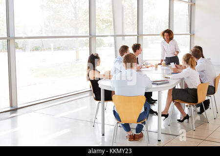 Imprenditrice rivolgendosi ai colleghi in una moderna sala riunioni Foto Stock