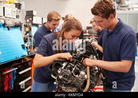 Apprendista meccanici a lavorare su un motore Foto Stock