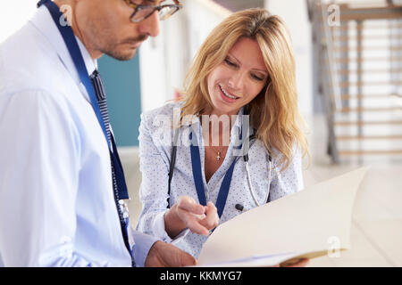 Giovane maschio e femmina medici consulting note alla riunione Foto Stock