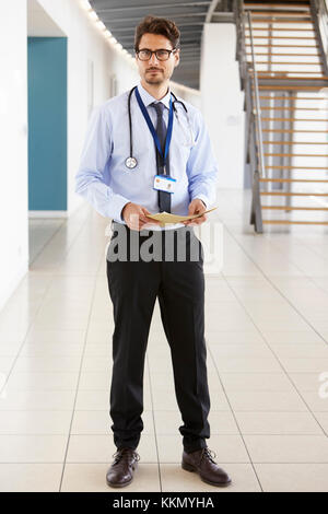 Ritratto di un giovane maschio medico tenendo note a piena lunghezza Foto Stock