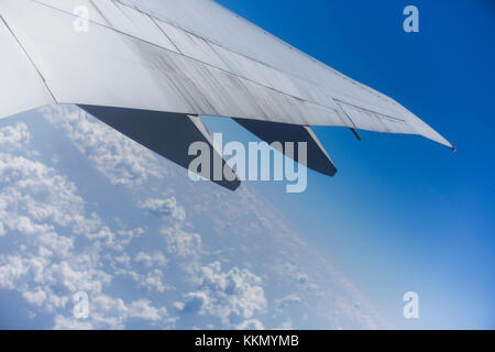 Vista dal lato destro di un aeromobile dell'ala, il piano è pronto a terra. Si tratta di una giornata soleggiata con un chiaro cielo blu con nuvole al di sotto di esso. Foto Stock