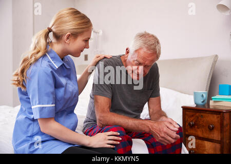 L'infermiera facendo visita a casa Senior uomo che soffre di depressione Foto Stock