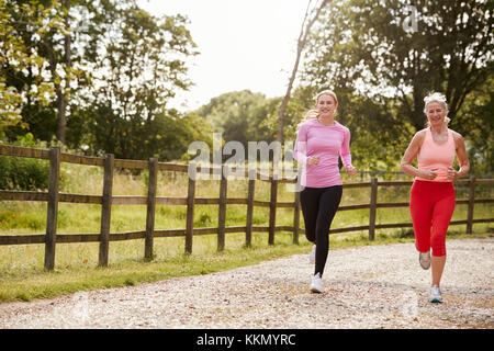 I giovani e le donne anziane godendo di eseguire attraverso la campagna insieme Foto Stock