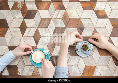 Vista superiore del giovane le mani con il caffè Foto Stock