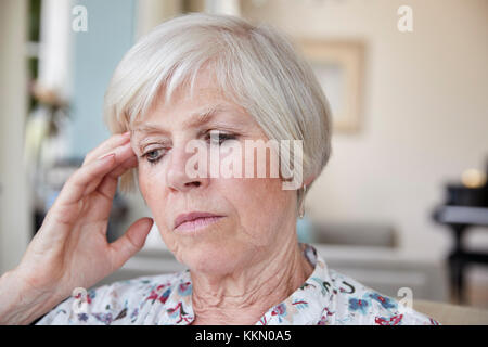 Contemplativa donna senior a casa, close up Foto Stock