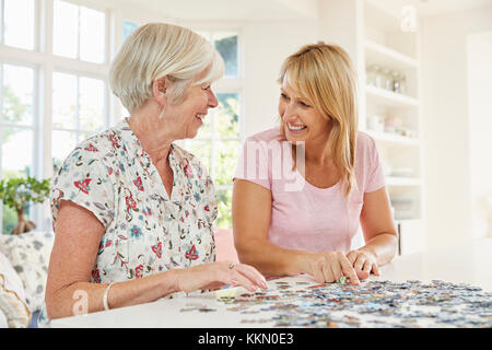 Coppia senior facendo un puzzle a casa Foto Stock