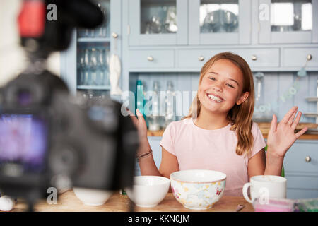 Pre-teen girl blog video in cucina sventolare le mani Foto Stock