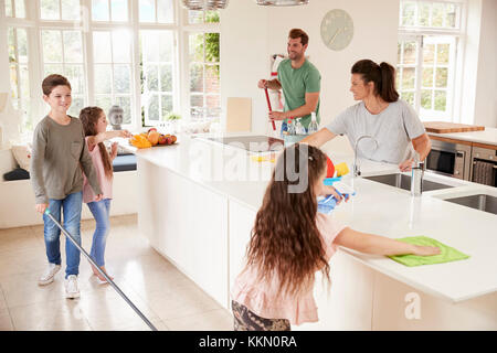 I bambini aiutano i genitori con mansioni domestiche in cucina Foto Stock