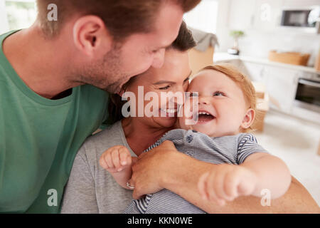 Close Up dei genitori abbracciando Happy Baby figlio a casa Foto Stock