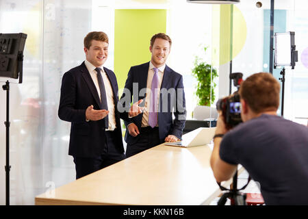 Cameraman e due imprenditori facendo un video aziendale Foto Stock