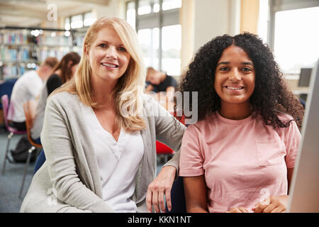 Insegnante e studente femmina di lavorare sul computer in un College Library Foto Stock