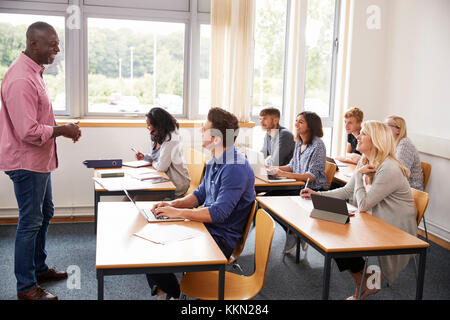 Maschio insegnamento tutor di classe di studenti maturi Foto Stock