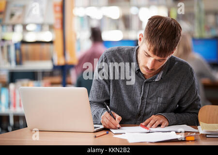 Maschio maturo studenti che lavorano su laptop in un College Library Foto Stock