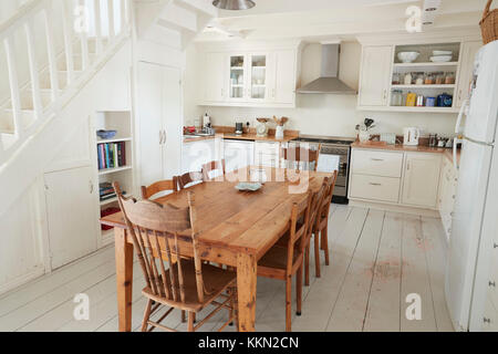 Vista interna di cucina con tavolo da pranzo in legno Foto Stock