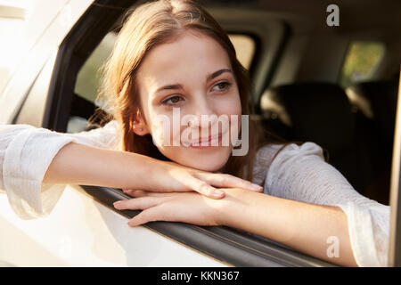 Ragazza adolescente guardando fuori della finestra Auto per la Famiglia Viaggio su strada Foto Stock