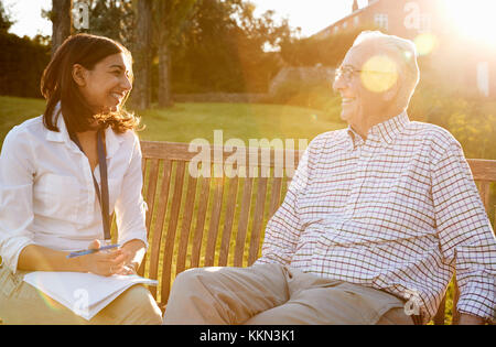 Donna visitando Senior parente maschio In Assisted Living Facility Foto Stock