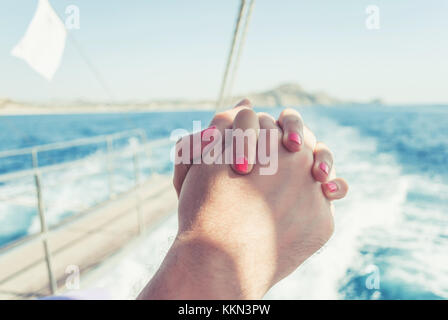 L uomo e la donna Holding Hands, su uno yacht, di libertà e di amore per il mare Foto Stock