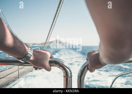 L'uomo sullo yacht, guardando verso il mare, con le mani appoggiate sulla ringhiera, vicino la mano Foto Stock