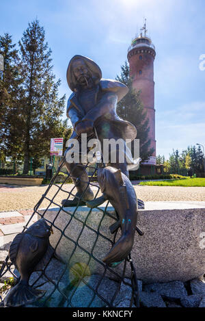 Scultura di pescatori di fronte al faro del Mar Baltico nel villaggio di Jaroslawiec nel Voivodato Pomeriano occidentale della Polonia Foto Stock