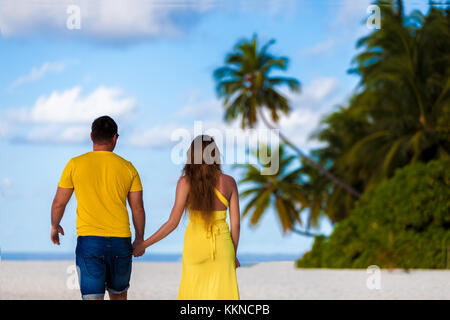 Maldive, una coppia a piedi lungo la spiaggia Foto Stock
