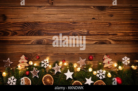 Sfondo di natale con decorazioni in legno e le luci spot. Libera spazio per testo. celebrazione e design decorativo. Foto Stock