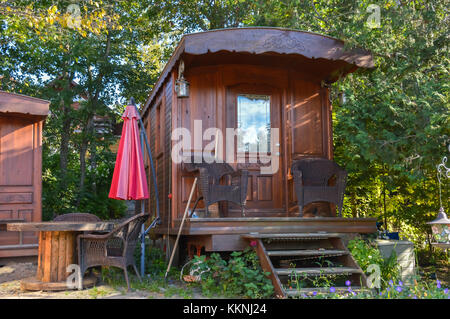 Ecologico di piccola casa in legno in Canada. casa in legno con prato di fronte ad esso. Foto Stock