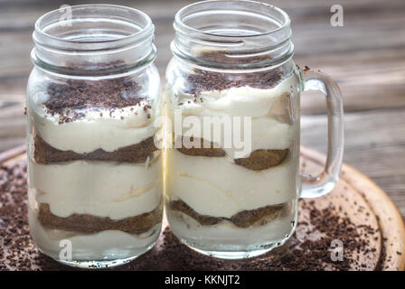 Il tiramisù in vasetti di vetro sullo sfondo di legno Foto Stock