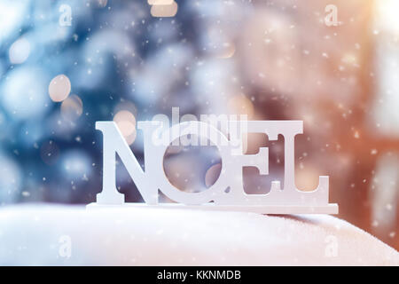 Il francese il Natale decorazioni in legno, closeup foto di una parola in legno Noel all'esterno in caso di neve, Felice Natale, nuovo bellissimo sfondo Anno Foto Stock