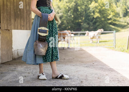 Contadino con dirndl portante un campanaccio Foto Stock
