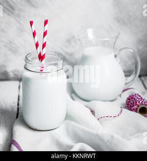 Barattolo di latte su legno sfondo rustico Foto Stock