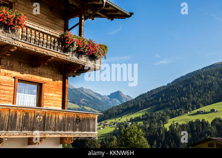 Un tipico balcone in legno con fiori in Alpbach, una città in Austria occidentale nello stato del Tirolo Foto Stock