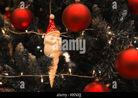 Christmas Santa Claus con lunghi orso bianco sorridente appeso su un bellissimo albero di natale circondato da red splendenti sfera Foto Stock