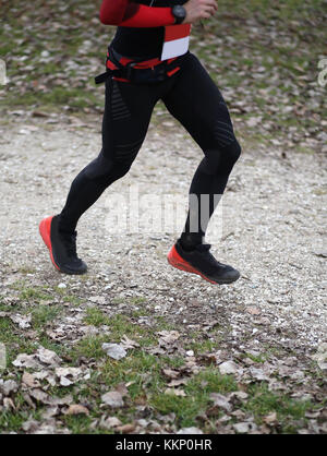 Unico runner in esecuzione nel paese strada durante una corsa con le scarpe da ginnastica e sportwears Foto Stock