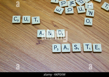 1 dicembre 2017 ivory board game lettere dicendo tagliare e incollare su di un grano di quercia background in bangor Irlanda del Nord Foto Stock