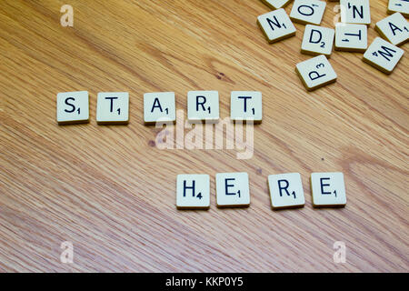 1 dicembre 2017 ivory board game lettere dicendo inizia da qui su di un grano di quercia background in bangor Irlanda del Nord Foto Stock