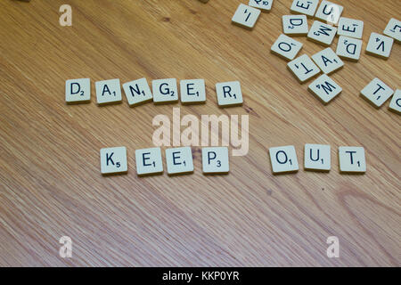 1 dicembre 2017 Ivory board game lettere dicendo pericolo Tenere fuori su una quercia sullo sfondo della granella in Bangor Irlanda del Nord Foto Stock