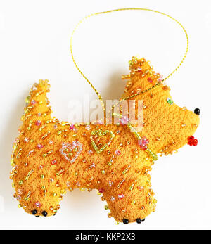 Anno nuovo giocattolo realizzato in tessuto e perline (yellow dog - simbolo del 2018) Foto Stock